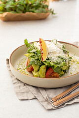 Portion of gourmet avocado salad with tomato and greens