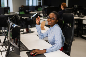 Portrait of an African young woman at a desk in the office.