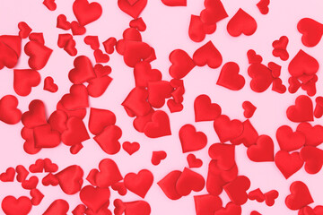 Texture made of textile red confetti in a heart shape on a pink background. Creative concept.