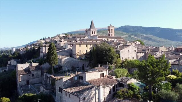 Aerial view of the church Santa Maria Maggiore in Spello, a charming town in Umbria, province of Perugia, dolly move backward from downhill