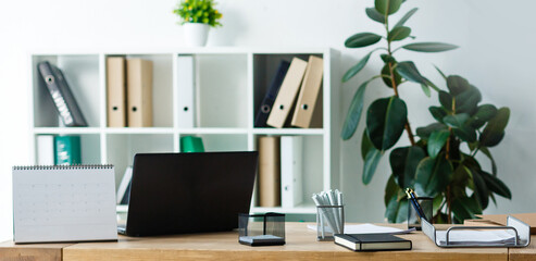 Blank computer desktop with keyboard, diary and other accesories on white table