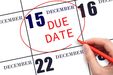 Hand writing text DUE DATE on calendar date December 15 and circling it. Payment due date