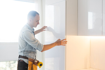 kitchen installation. Worker assembling furniture