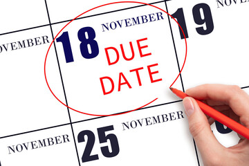 Hand writing text DUE DATE on calendar date November 18 and circling it. Payment due date