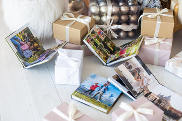 Photo book album under the Christmas tree surrounded by Christmas gifts