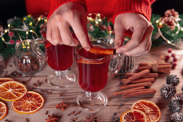 Fototapeta na wymiar Christmas mood, holiday atmosphere. The girl prepares mulled wine on a wooden table.