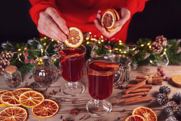 Christmas mood, holiday atmosphere. The girl prepares mulled wine on a wooden table.