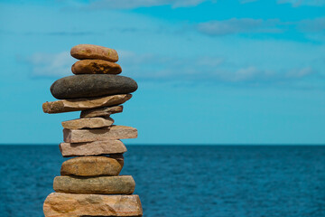 Stack of rocks. Stone tower with ocean blur in background
