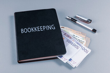 Cash counting. Accounting black book, euro banknotes and fountain pen on background