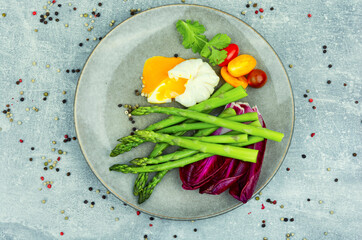 Salad of asparagus, lettuce and poached eggs, flat lay