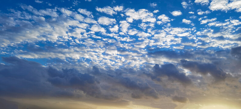 Natural backgrounds. Blue sky with sun and clouds at sunrise