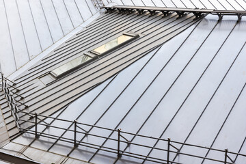 Metal roof with railings and attic window, modern architecture