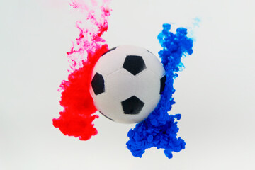 Soccer ball with red and blue color splash on white background.
