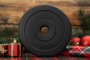 Dumbbell barbell weight plate disc on gift wrapping paper. Exercise equipment as Christmas present...