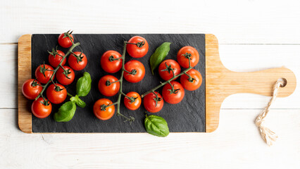 Fresh cherry tomatoes and basil on slate plate