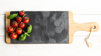 Fresh cherry tomatoes and basil on slate plate