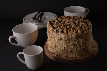 photo whole walnut cake with dishes on a black background
