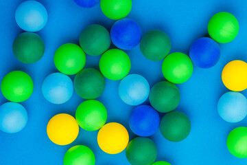 Abstract colored balls background. Multi-colored taw toy scattered on bright paper. Base for design nice backdrop, wallpaper, poster. Noisy surface texture