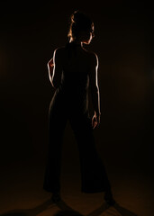 Girl in silhouette. Black sparkling overall