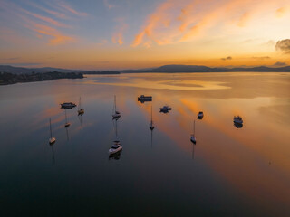 Sunrise over the water with fog, boats, clouds and reflections