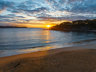Aerial sunrise seascape with calm seas and a mix of low and medium clouds
