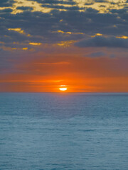 Orange sky sunrise with sun on the horizon and clouds