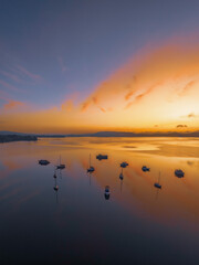 Sunrise over the water with fog, boats, clouds and reflections
