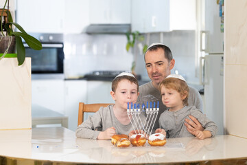 Father and sons with menorah celebrate hanukkah - Jewish religious holiday