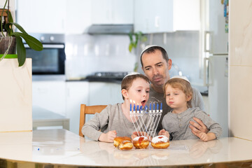 Father and sons with menorah celebrate hanukkah - Jewish religious holiday