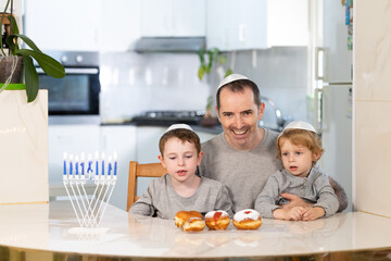 Father and sons with menorah celebrate hanukkah - Jewish religious holiday