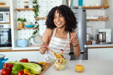 Young Woman Cooking in the kitchen. Healthy Food - Vegetable Salad. Diet. Dieting Concept. Healthy Lifestyle. Cooking At Home. Prepare Food