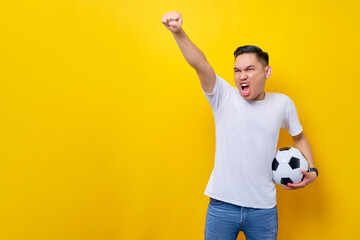 fans excited to support the football sports team.  Asian man 20s wears white t-shirt holding a...