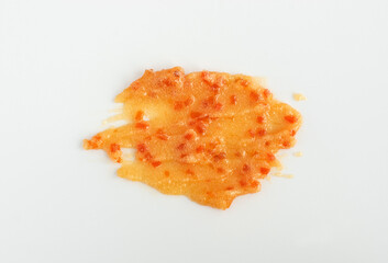 Orange face or body exfoliating scrub texture. Beauty mask smear on white background. Cosmetic product swatch close-up.