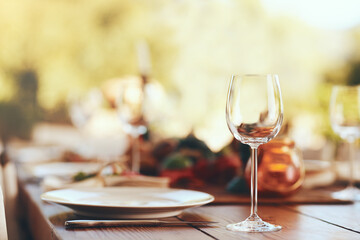 Empty wine glass, plate and cutlery on a table for a dinner, party or event at a restaurant. Glass, table setting and dinnerware for an outdoor luxury festive, holiday or celebration banquet or feast