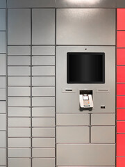 Grey automated parcel post terminal with blank screen waiting for clients