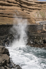 ocean waves gushing on volcanic cliffs at Porto de Cruz, Madeira