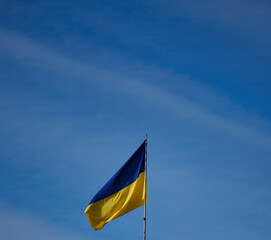 The yellow-blue flag of Ukraine is flying on a building in Kherson against the blue sky
