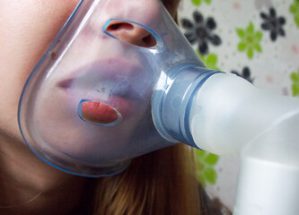 The girl conducts inhalation. Inhalation of the throat and nose. Close-up