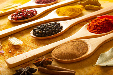 various spices in wooden spoons