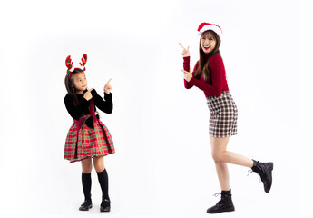 Young asian woman and girl in red christmas theme costume wear santa hat posing finger pointing...