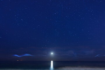 night seascape with star tracks and moon path