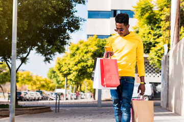 African young man walking with shopping bags