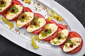Sliced tomatoes with cheese and garlic sauce on a plate
