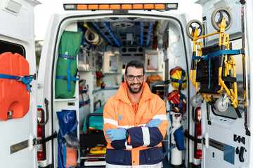 portrait of a smiling paramedic with arms crossed next to an ambulance