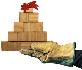Hand with protective work gloves holding a small wooden Christmas tree, made of small wooden cubes...