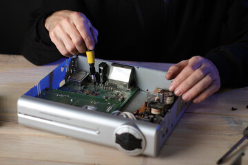 repair of a satellite tuner by a person on a table