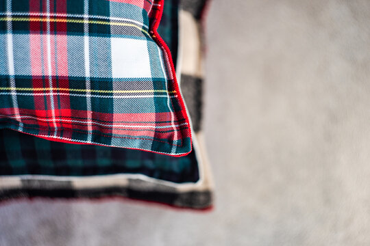 Close-up of a stack of assorted pillows with various checked patterns on a shelf