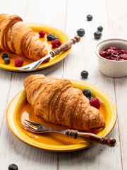 Tasty sweet croissant with blueberries and raspberries