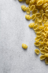 Flat lay of uncooked Gnocchetti pasta shells, top view of gnocchi pasta shells, dry uncooked macaroni	