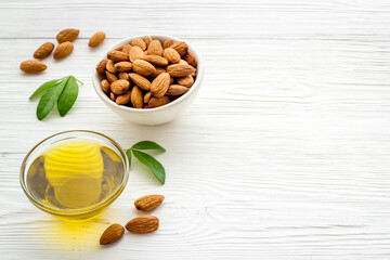 Almond nuts and almond oil in glass jar. Organic food and cosmetic background
